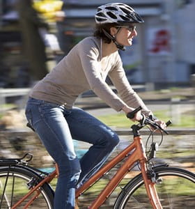 Vrouw fietst veilig in de stad met een goede fietsuitrusting.