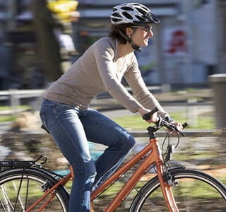 Femme à vélo en ville qui respecte les règles de sécurité