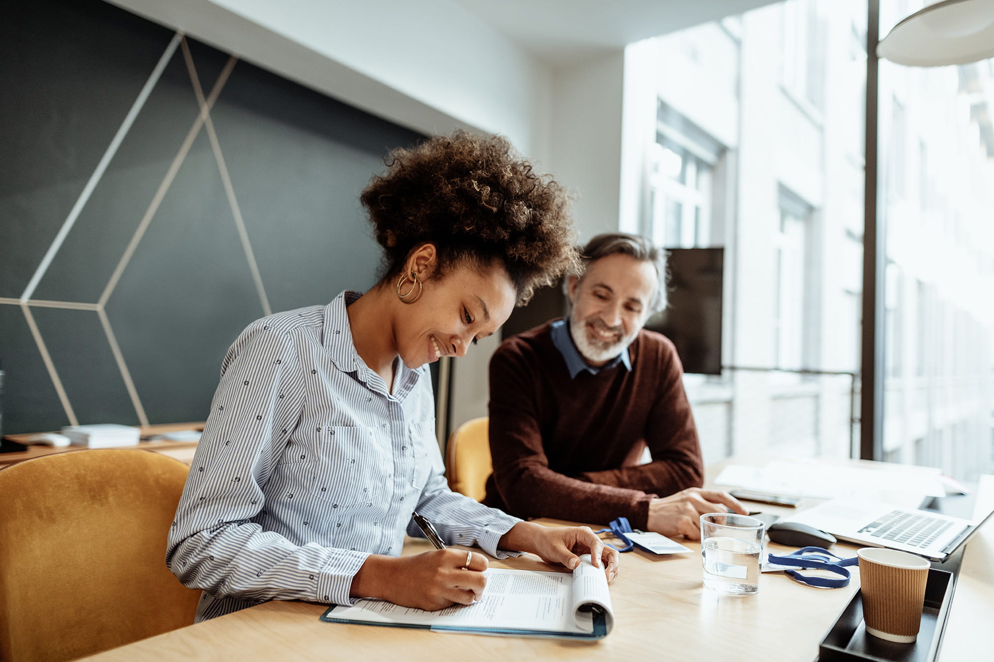 Une femme accompagnée de son intermédiaire en assurances pour changer de formule d’assurance concernant l’ajout ou la suppression d’une garantie à son contrat d’assurance 