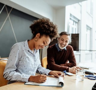 Een vrouw bespreekt met haar verzekeringstussenpersoon hoe ze de dekkingen van haar verzekeringscontract kan wijzigen.