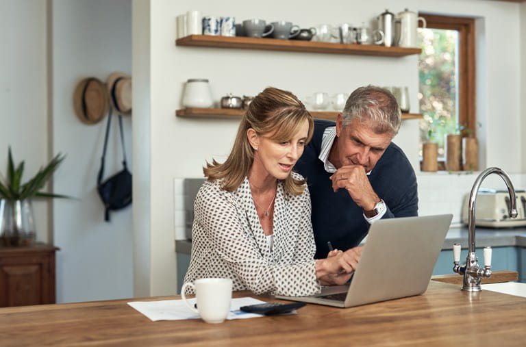 Koppel analyseert op de laptop de mogelijkheden van een levensverzekering in de context van de meerwaardebelasting.