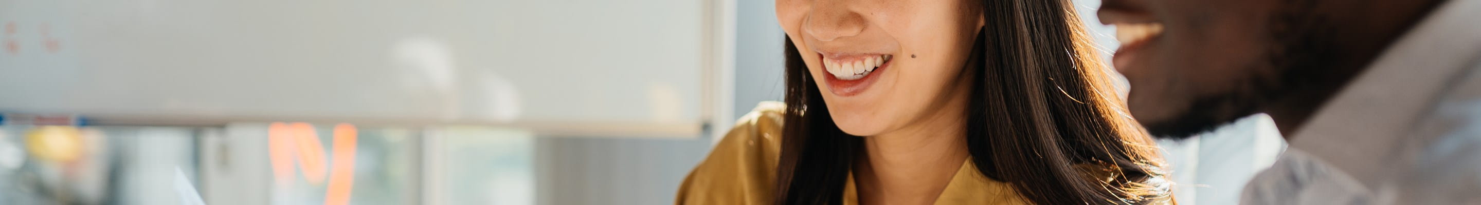 Twee collega’s bekijken samen een document op een laptop, om bij arbeidsongeschiktheid van de bedrijfsleider de continuïteit van de activiteit te garanderen.