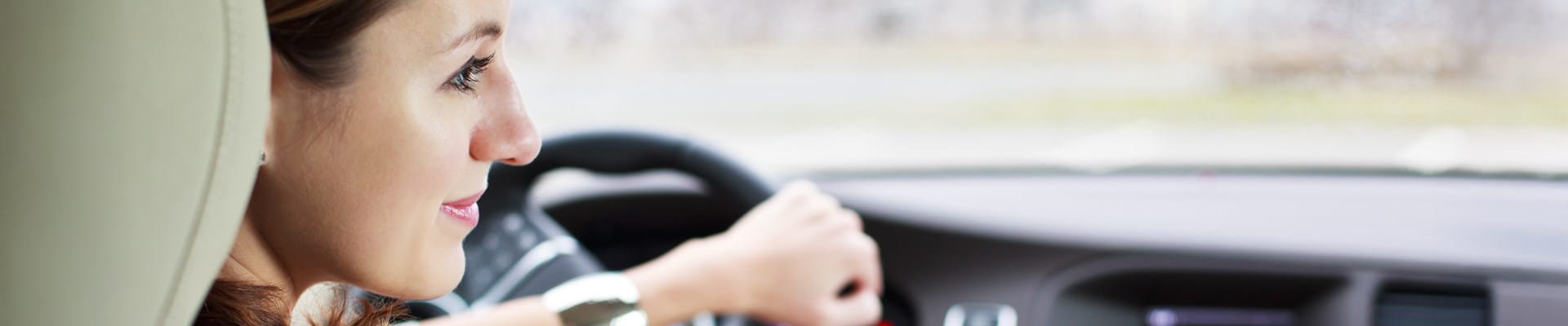 Une femme qui conduit tranquillement sa voiture, économisant du carburant.