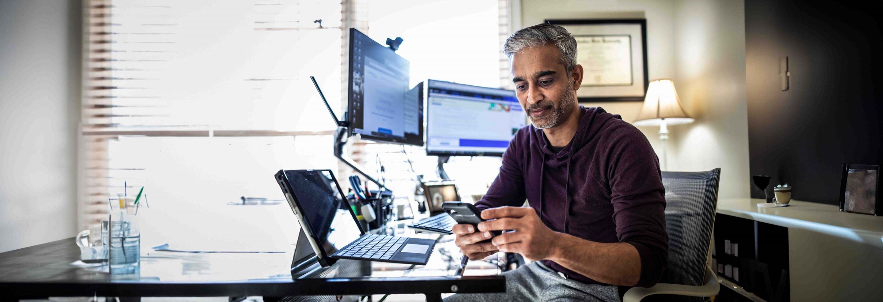 Man gebruikt artificiële intelligentie op zijn laptop en op zijn gsm. 