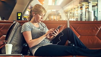 Vrouw moet wachten op de luchthaven omdat haar vlucht vertraging heeft.