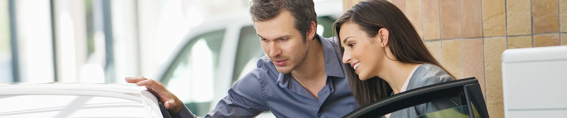 Un homme et une femme qui veulent acheter une voiture d'occasion.