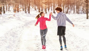 Deux jeunes gens profitent de la neige en hiver, ce qui leur assure un mode de vie sain.