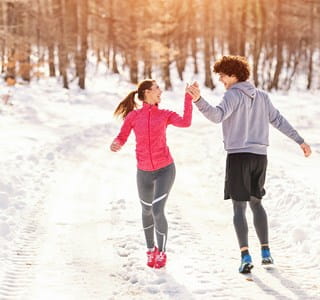 Deux jeunes gens profitent de la neige en hiver, ce qui leur assure un mode de vie sain.