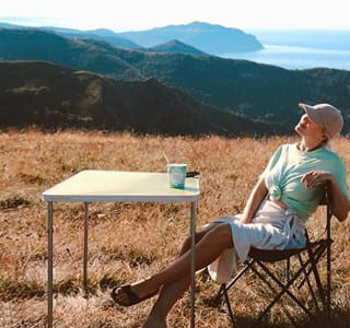 Vrouw geniet van de zon op reis dankzij onze traveltips voor een zorgeloze vakantie.