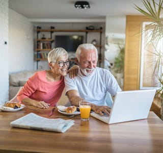 Een gepensioneerd echtpaar zoekt informatie op over beleggen in een beleggingsverzekering.
