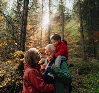 Un grand-père, sa fille et sa petite-fille se promènent dans la forêt et discutent de l’assurance-vie comme instrument de planification successorale.