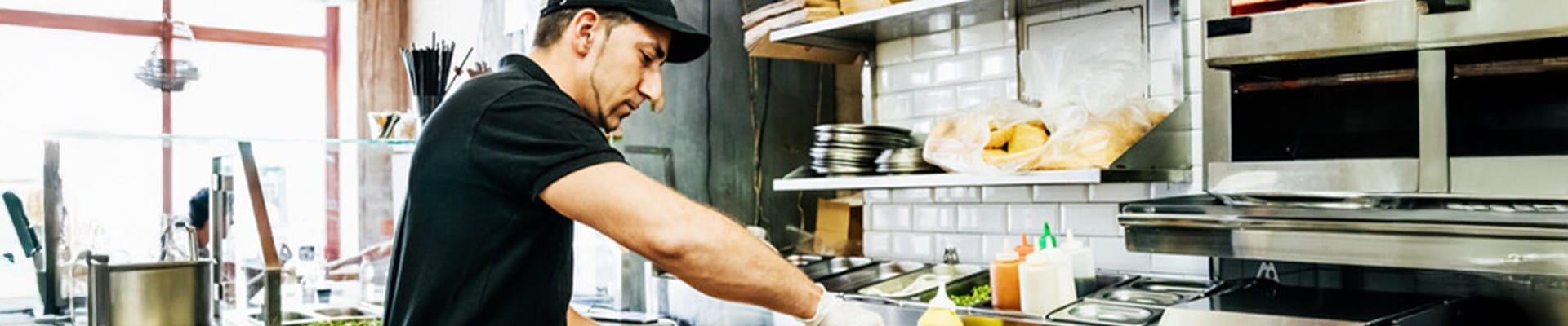 Un membre du personnel de l'horeca prépare et sert des plats selon les directives d'AFSCA et HACCP.