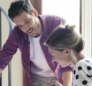 Couple qui regarde les plans de rénovation de leur maison en Wallonie.