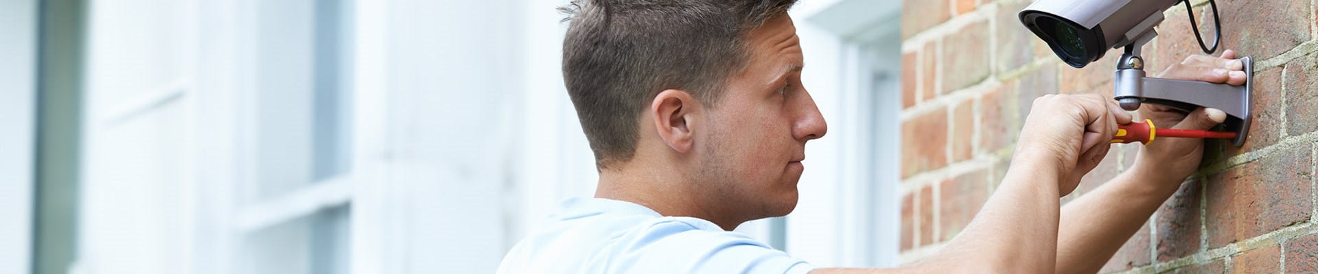 Homme installant une caméra comme protection contre le vol