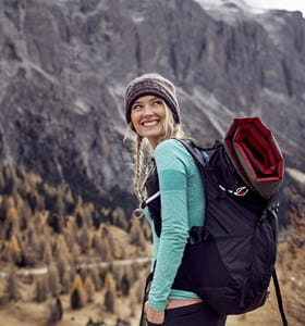 Femme qui part en randonnée après avoir comparé les assurances voyage.
