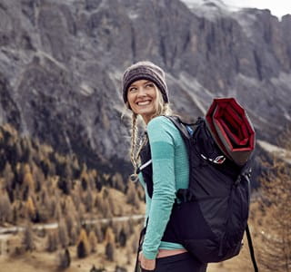 Femme qui part en randonnée après avoir comparé les assurances voyage.