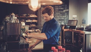 Een jobstudent of flexi-jobber werkt in een café naast zijn lesuren.