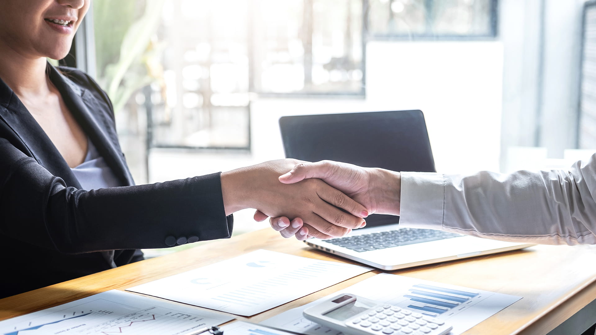 Medewerker van AXA die een klant uit de publieke sector begroet.