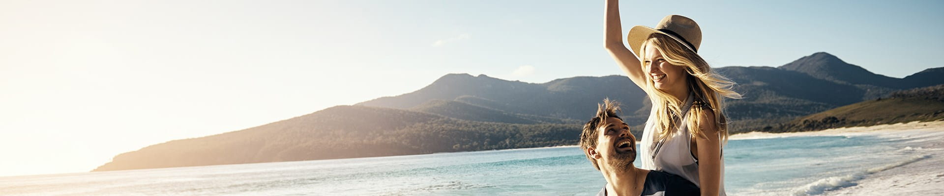 Jeune couple profitant d’une balade sur la plage, en toute sérénité avec une assurance voyage.